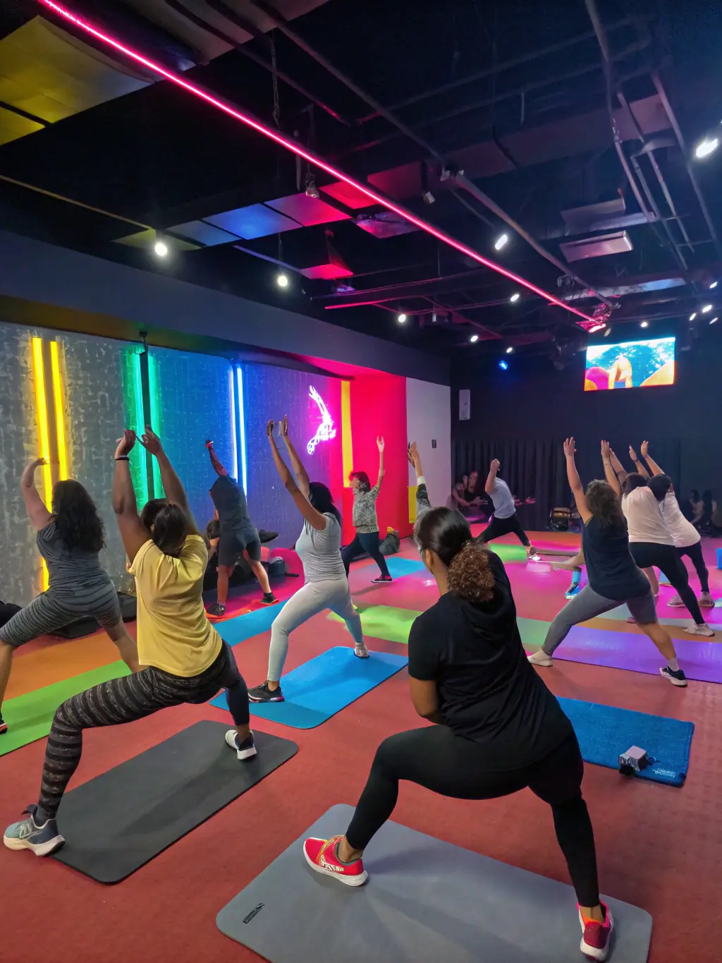A diverse group of people participating in a group fitness class, emphasizing teamwork and community engagement, led by an enthusiastic instructor.
